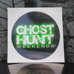This 3 inch diameter vinyl sticker has a black background with the ghost hunt weekends white logo printed in the middle with a green glow around it.